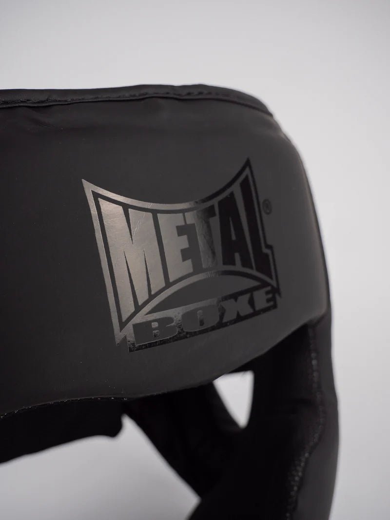 Close-up of the Metal Boxe logo printed on the shell of the black Full Face "Black Light" helmet