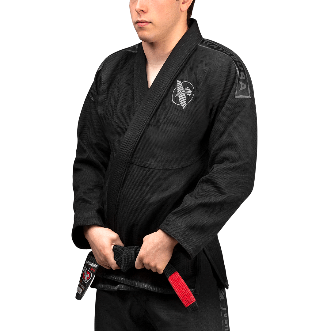 Framifrån av den svarta BJJ Hayabusa Lättvikts-kimonon med kontrasterande vita broderier