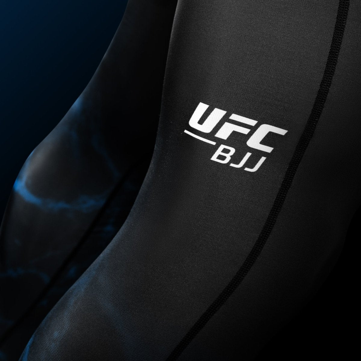 Close-up detail of the UFC writing printed on the leg of the black and blue BJJ Spats leggings