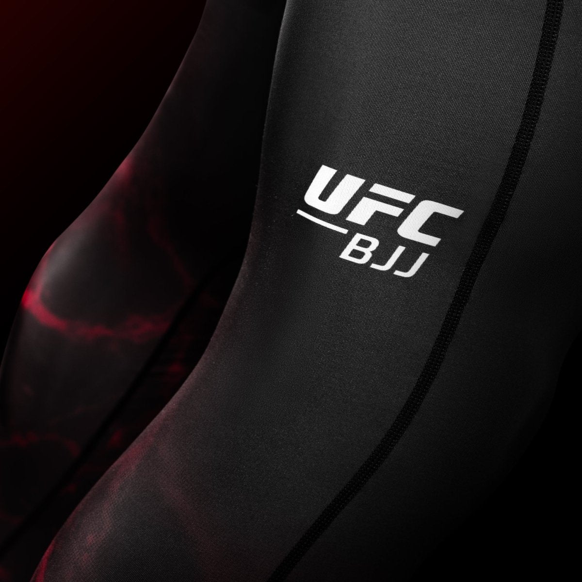 Close-up of the UFC graphic on the leg of the black and red BJJ Spats leggings, detail of the reinforced stitching