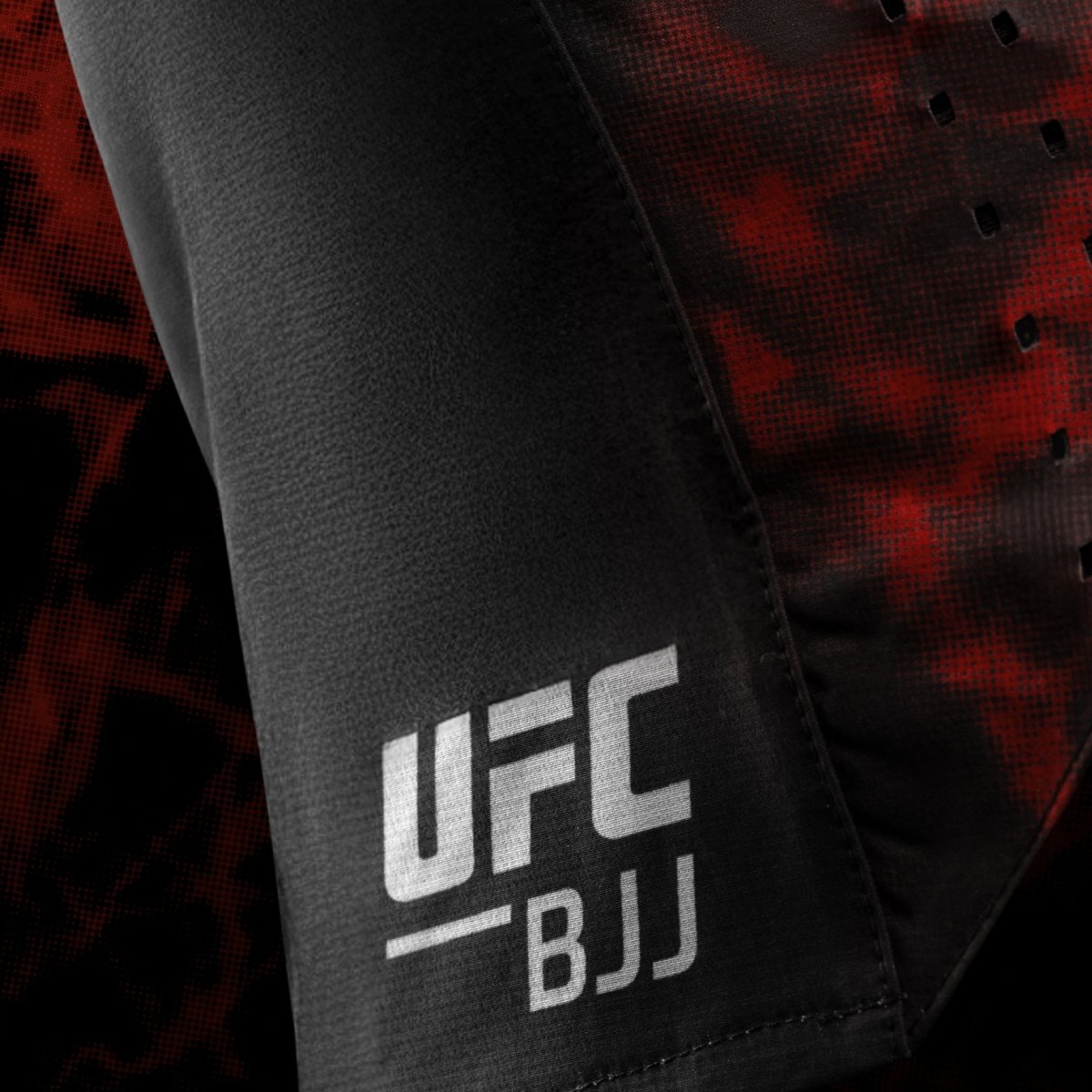 Close up of UFC BJJ side logo on black and red women's grappling shorts