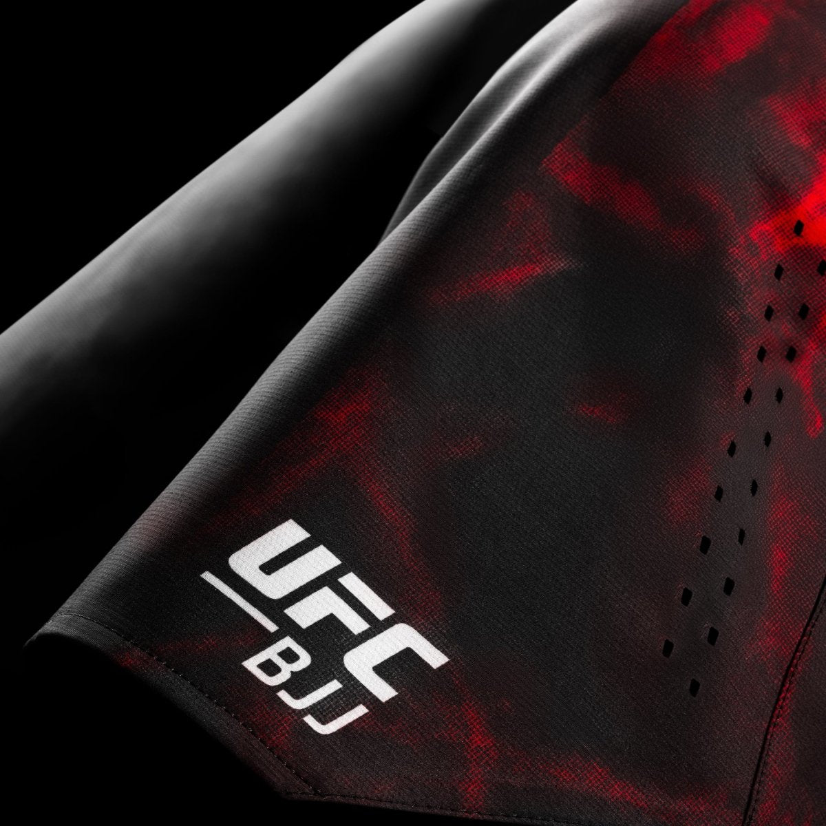 Close-up of the official UFC BJJ graphic printed on the black and red grappling shorts