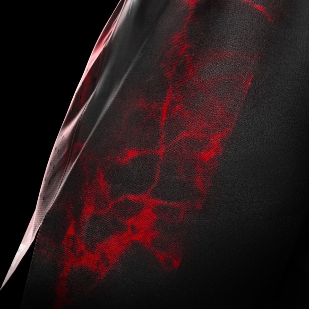 Side view of the black and red UFC BJJ shorts, detail of the vents for mobility and laser ventilation