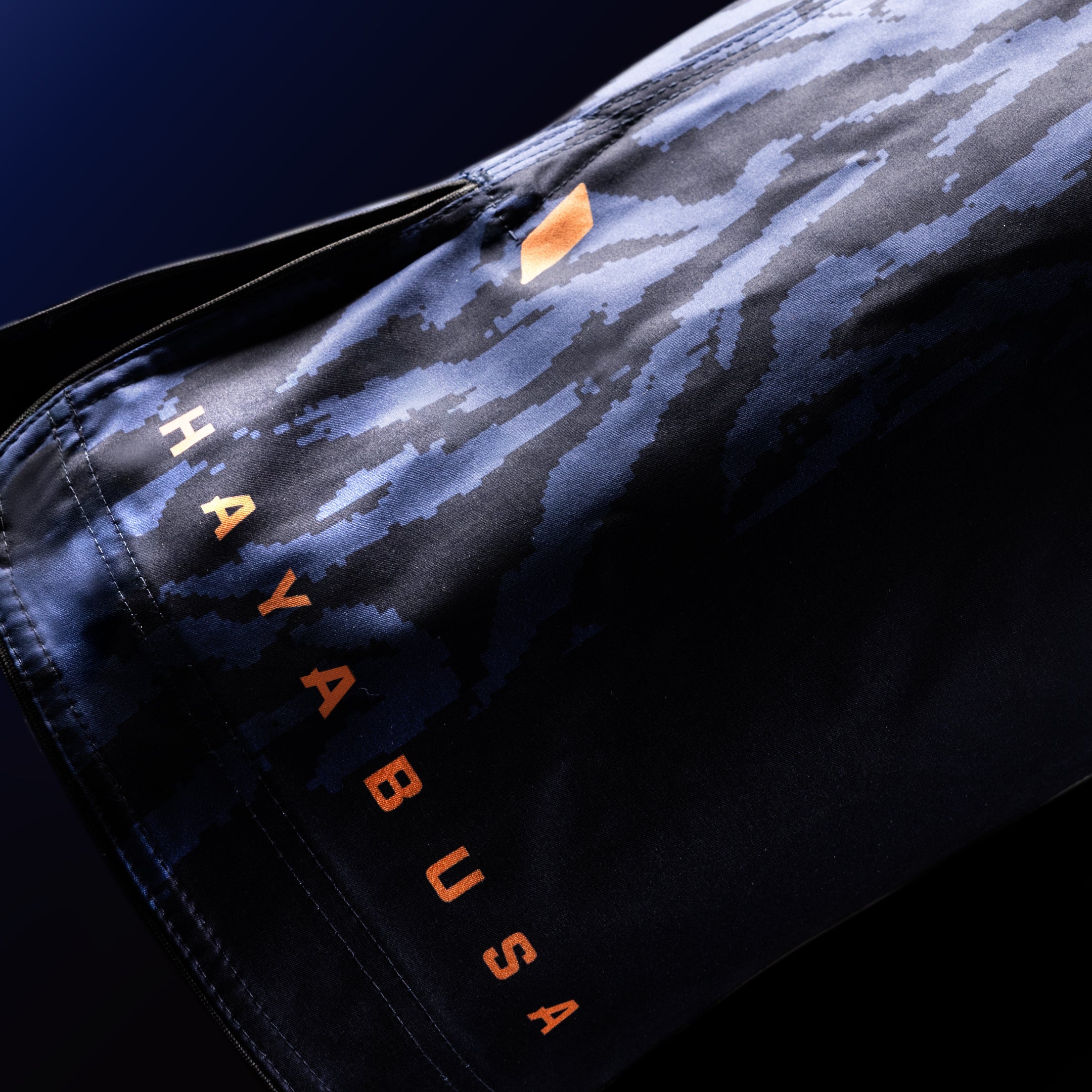Primo piano della scritta ufficiale Hayabusa sulla gamba dei pantaloncini blu da combattimento