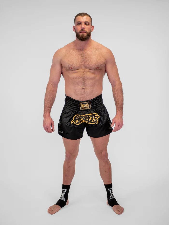 Detaliu al țesăturii tehnice și finisajelor pantalonilor scurți negri de Muay Thai pentru bărbați Metal Boxing