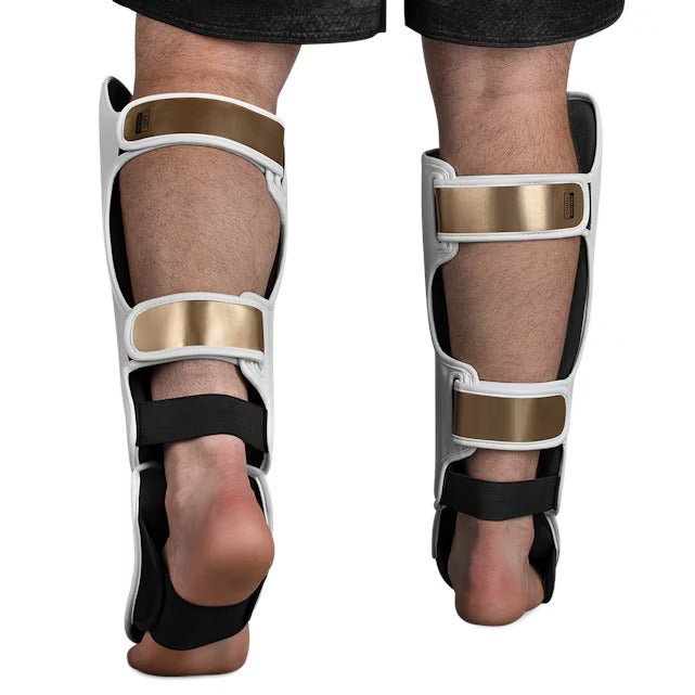 Rear view of the white and gold Hayabusa T3 Striking shin guard, with detail of the adjustable closure straps