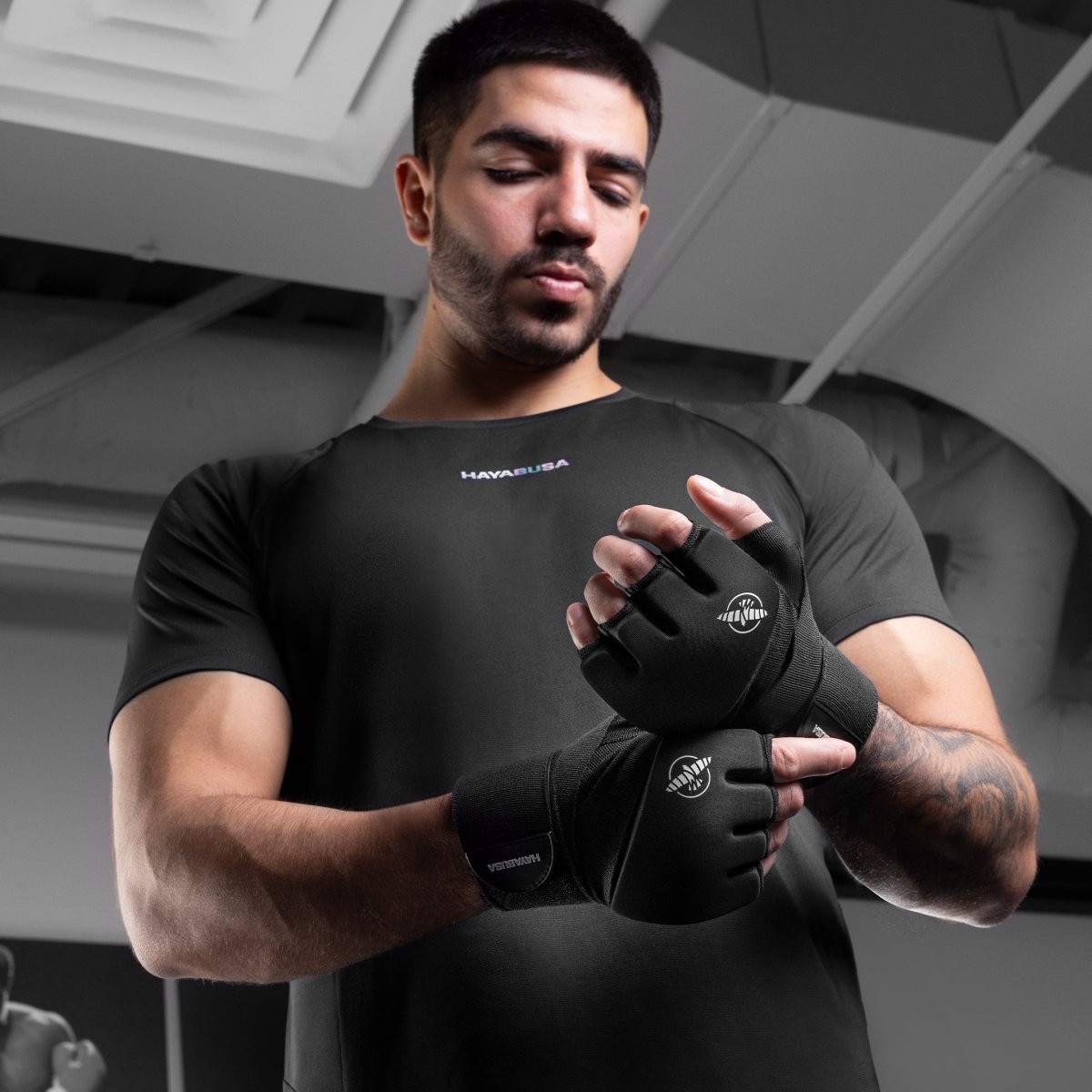 Černé vložky Hayabusa Elite, které nosí muž, ukazující padnutí prstů a zapínání na zápěstí