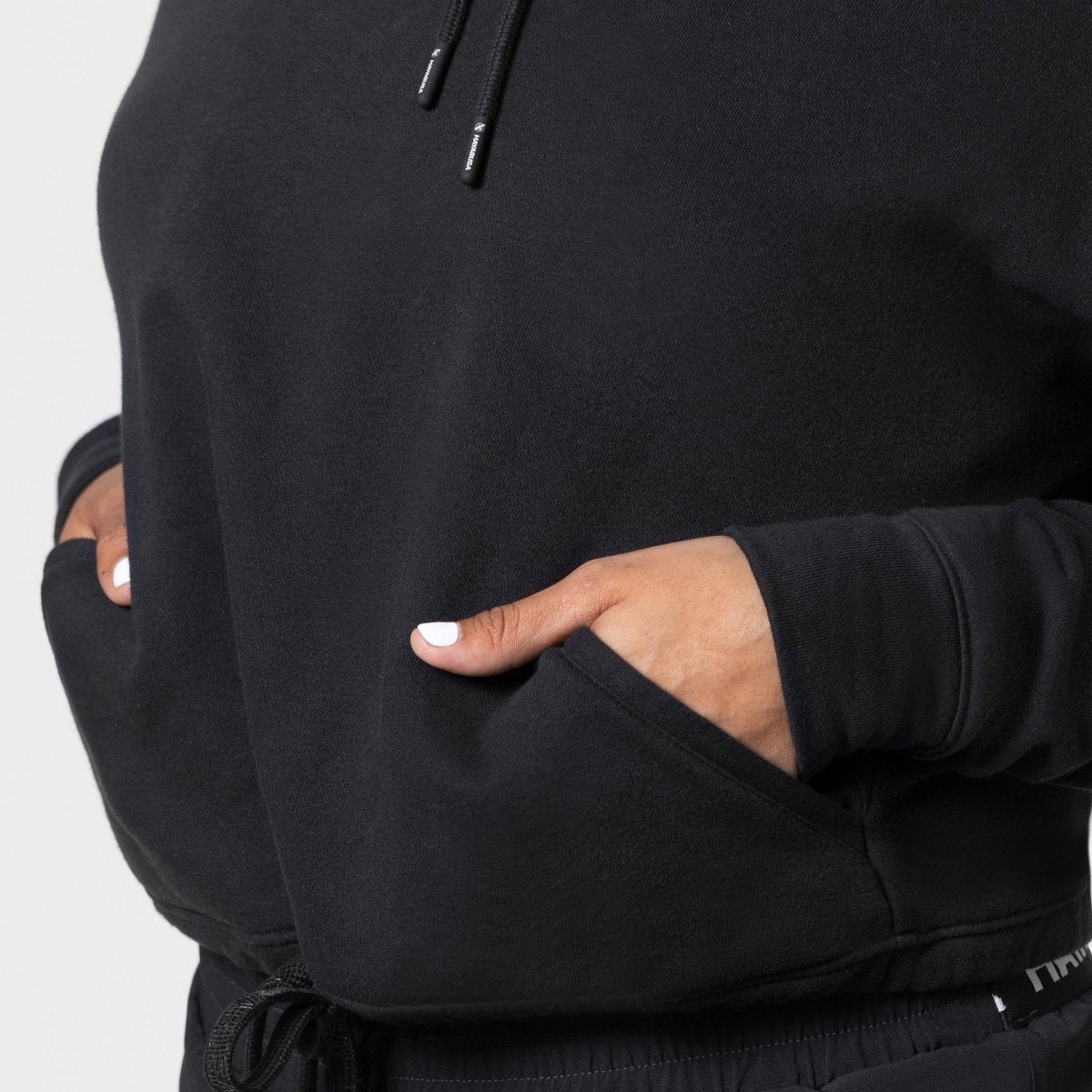 Detail saku depan terbuka pada cropped sweatshirt Hayabusa berwarna hitam