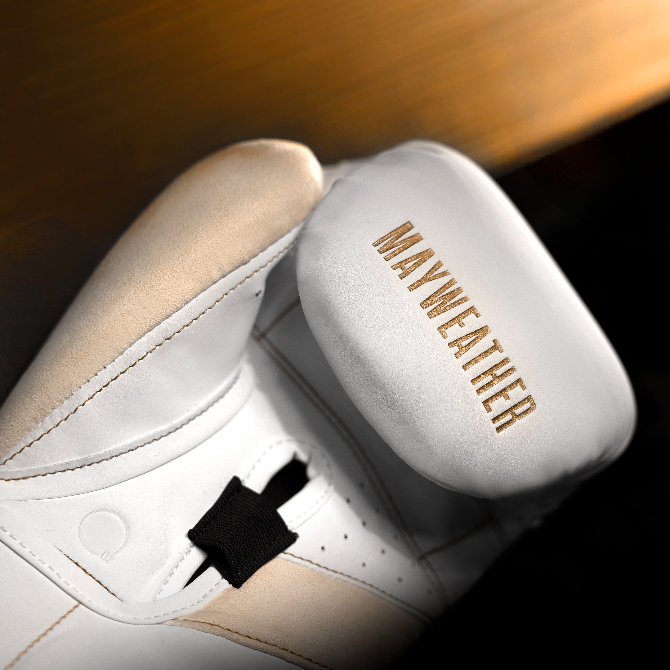 Dettaglio dell'imbottitura interna e della barra di presa angolata dei guantoni Mayweather Champ bianco oro