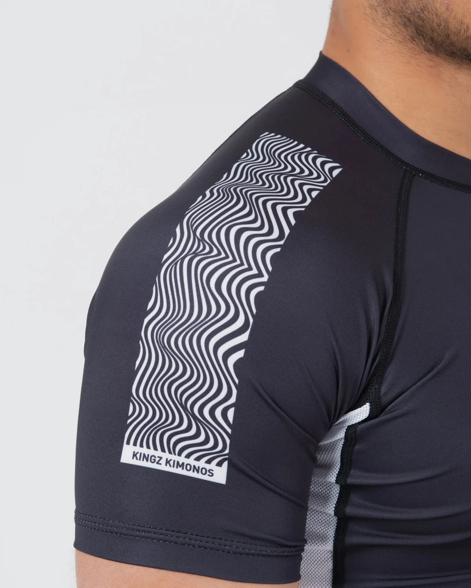Detail van de schouder en versterkte stiksels op de zwarte Kingz Flow rashguard