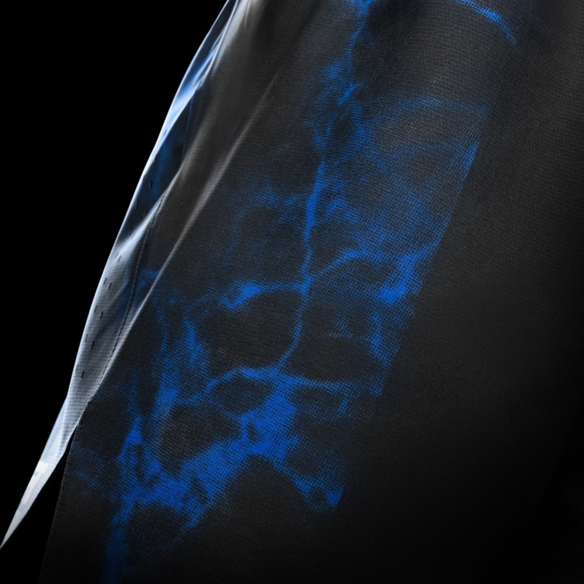 Side view of the black and blue UFC BJJ shorts, highlights the lightweight and breathable technical fabric