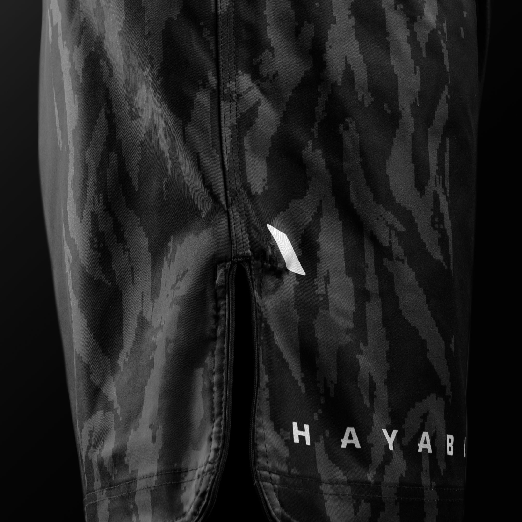 Vista laterale dei pantaloncini MMA Hayabusa Apex Mid-Thigh neri con dettaglio degli spacchi per la massima mobilità