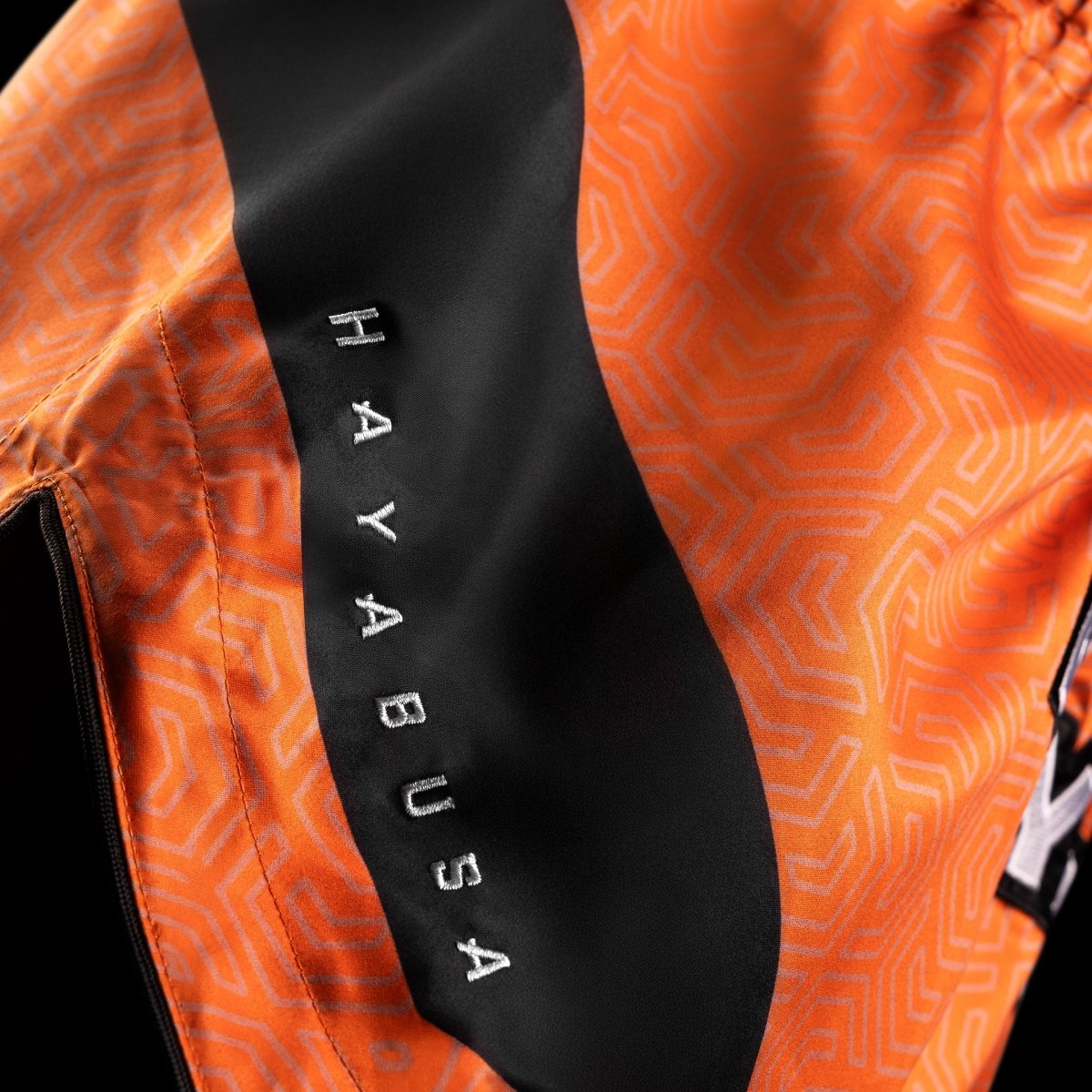 Detail of the shiny finish and fabric resistance of the orange Hayabusa Core shorts