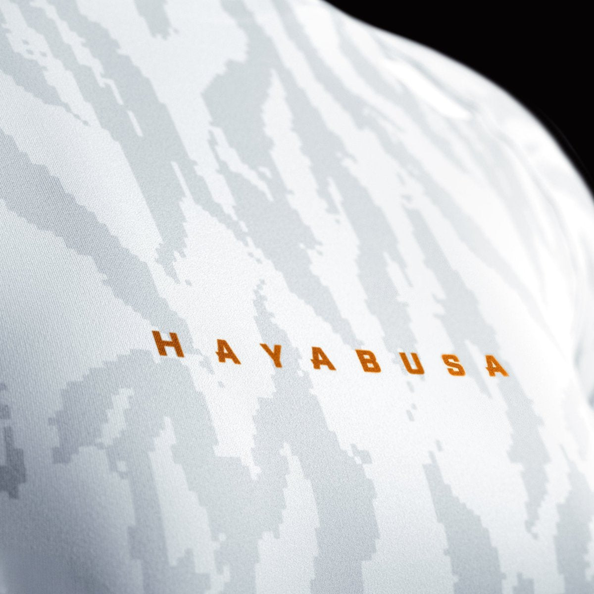 Närbild av Hayabusa-trycket framtill på den vita kvinnliga rashguarden, detalj av den sammanfogade sömkragen